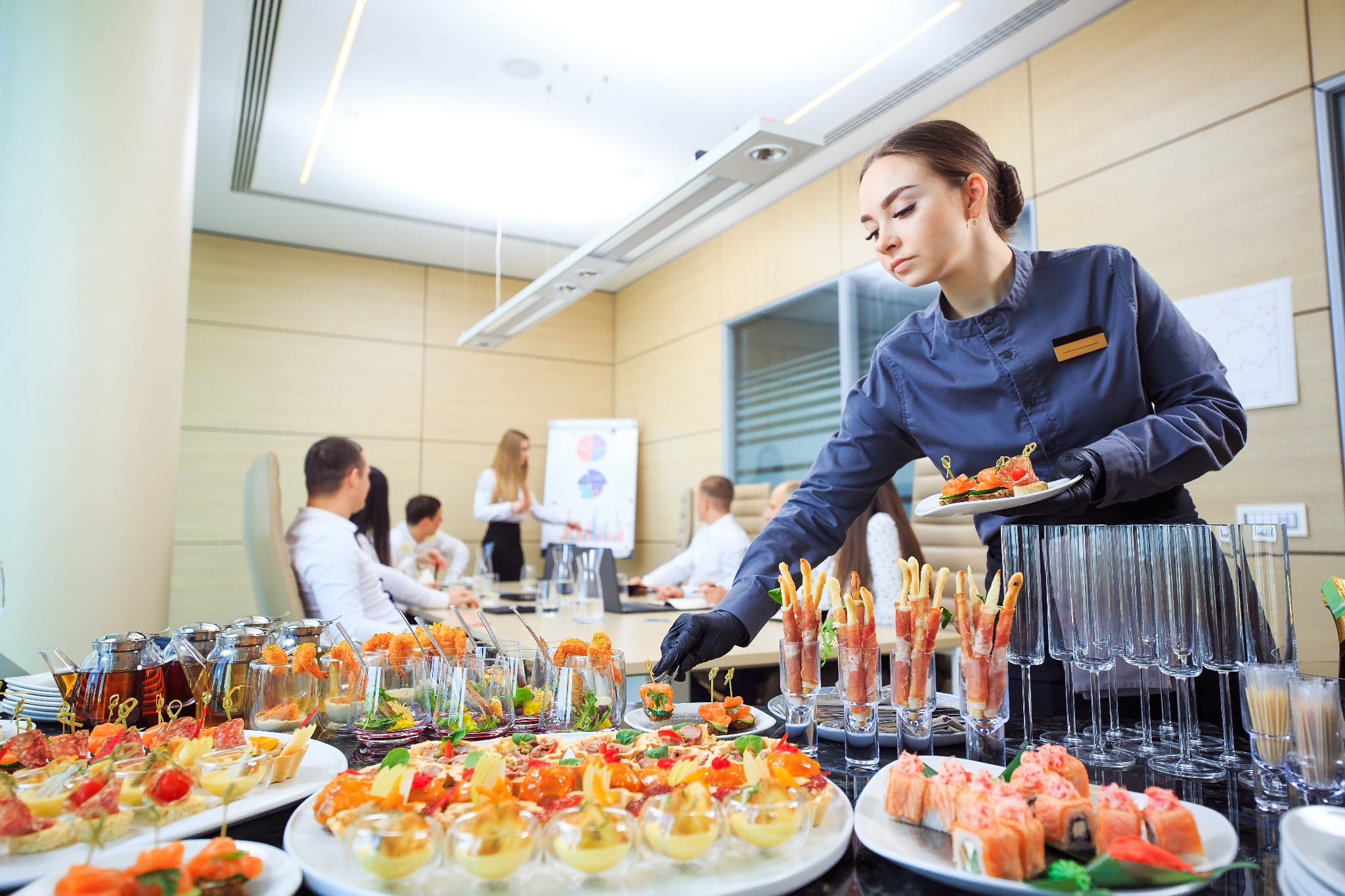 Professional caterer serving gourmet appetizers during a corporate meeting, showcasing high-end catering service with elegant presentation